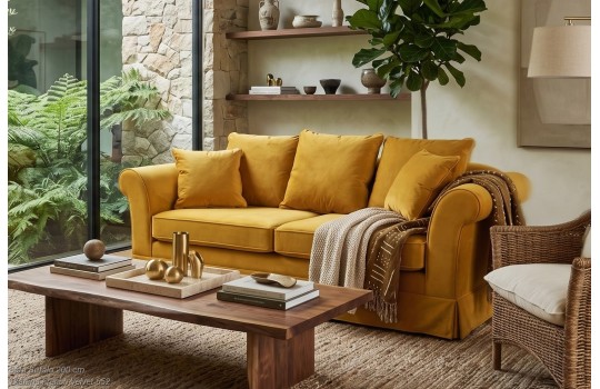 Musztardowa sofa Bufalo 200 cm w salonie z drewnianym stolikiem kawowym i wiklinowym fotelem