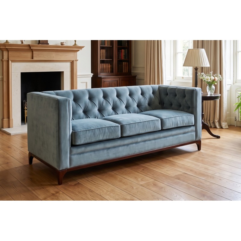 Sofa chesterfield z drewnianą podstawą Mobius 200 cm w niebieskim welurze w salonie z kominkiem