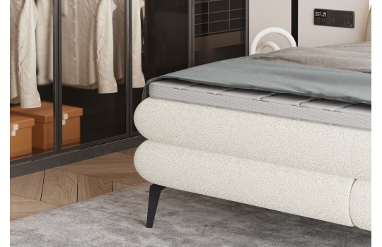 łóżko na wysokich czarnych nogach 