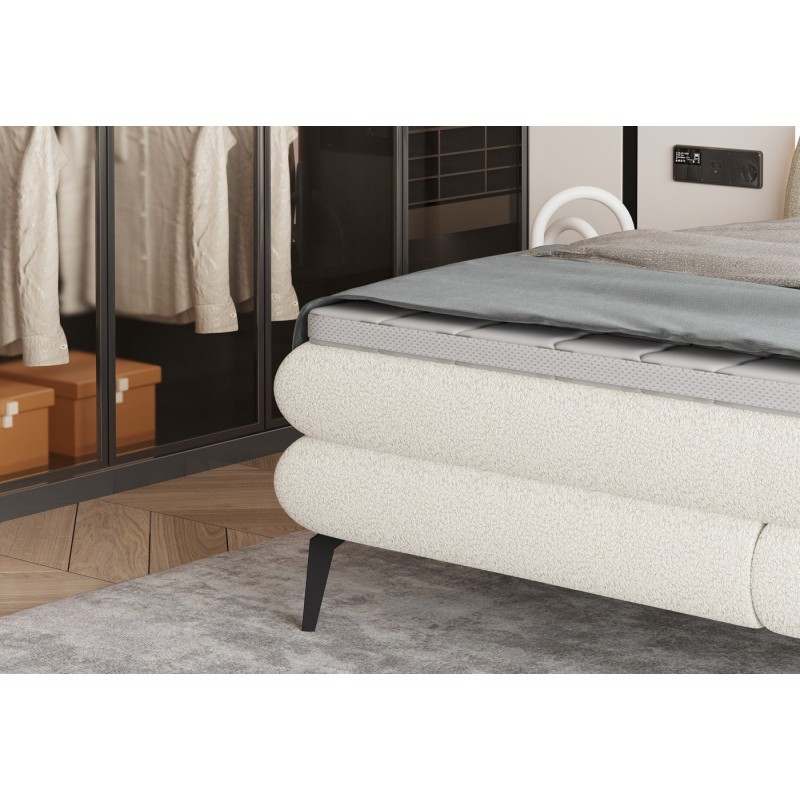 łóżko na wysokich czarnych nogach 