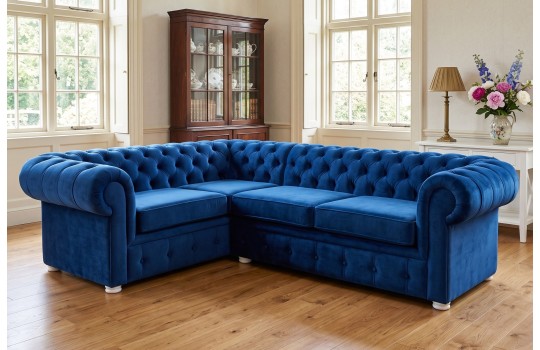 Granatowy narożnik chesterfield Malard 230 x 170 cm w salonie z witryną i jasnymi nóżkami