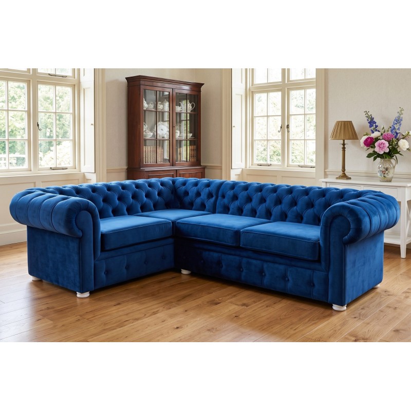 Granatowy narożnik chesterfield Malard 230 x 170 cm w salonie z witryną i jasnymi nóżkami