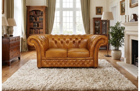 Klasyczna sofa Chesterfield Wonder – koniakowa skóra z pikowaniem w salonie z biblioteką Klasyczna sofa Chesterfield Wonder – koniakowa skóra z pikowaniem w salonie z biblioteką