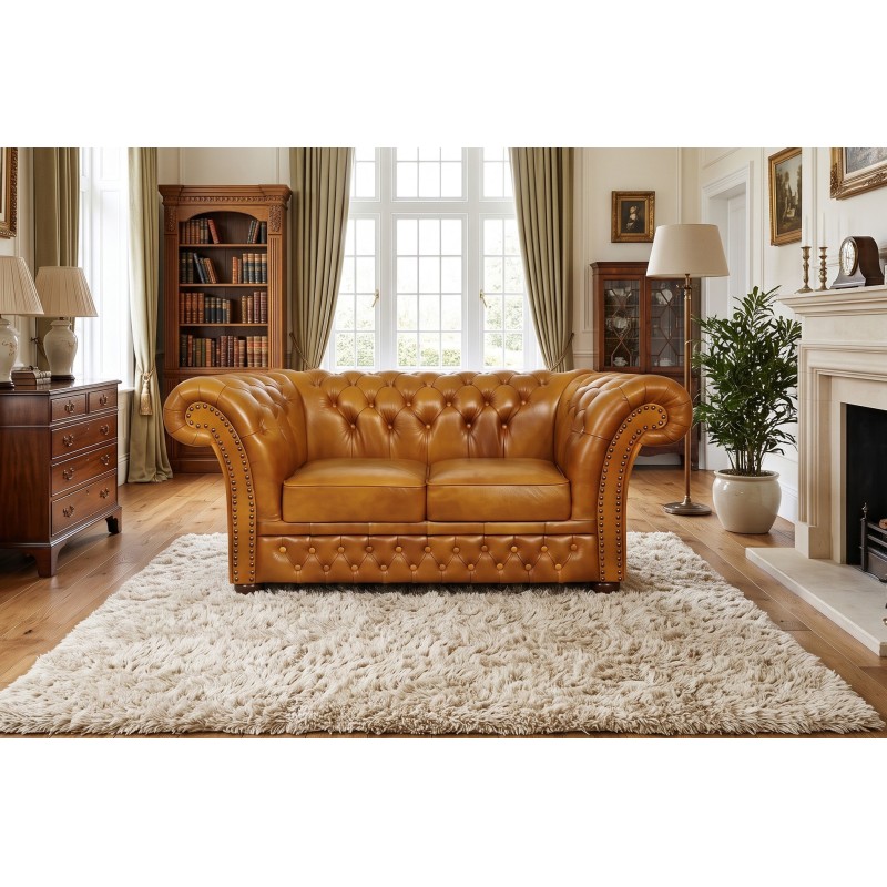 Klasyczna sofa Chesterfield Wonder – koniakowa skóra z pikowaniem w salonie z biblioteką Klasyczna sofa Chesterfield Wonder – koniakowa skóra z pikowaniem w salonie z biblioteką