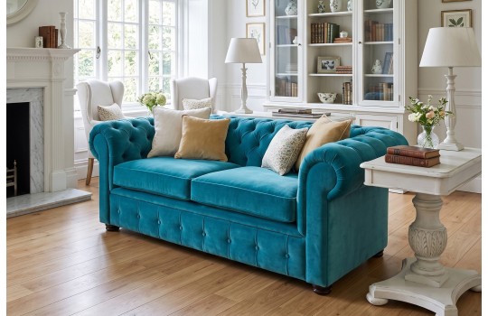 Turkusowa sofa Retro Chesterfield 190 cm z pikowaniami – welur i poduszki w jasnym salonie
