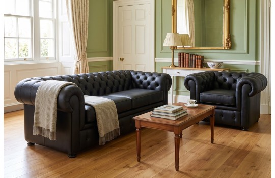 Chesterfield sofa w czarnej skórze – komplet z fotelem w klasycznym, jasnym salonie Chesterfield sofa w czarnej skórze – komplet z fotelem w klasycznym, jasnym salonie