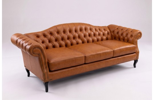 Koniakowa sofa ze skóry naturalnej Solano 250 cm na toczonych nóżkach na jasnym tle