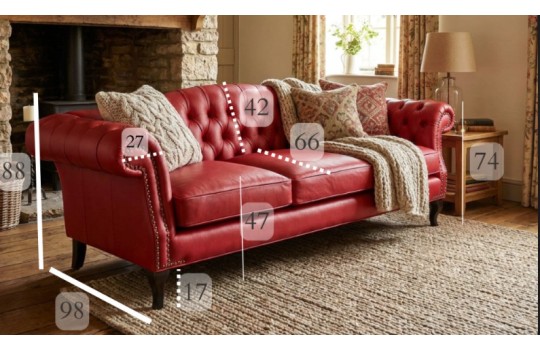 Czerwona skórzana sofa chesterfield Solano z poduszkami i wymiarami w klasycznym pokoju dziennym