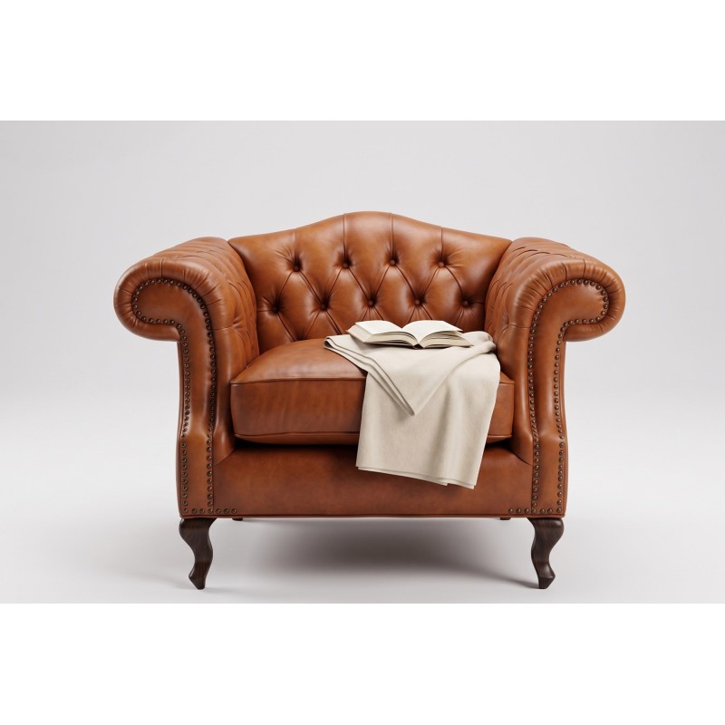 Koniakowy skórzany fotel chesterfield z kremowym pledem na ciemnych nóżkach