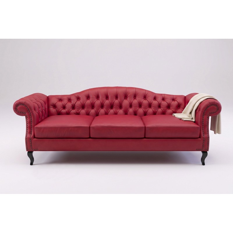 Czerwona trzyosobowa sofa chesterfield z białym kocem na gładkim tle
