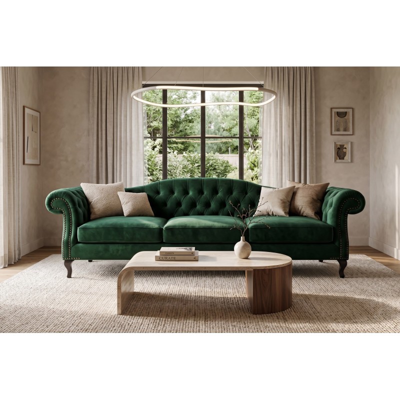 Ciemnozielona welurowa sofa chesterfield Solano z poduszkami przy owalnym stoliku kawowym Ciemnozielona welurowa sofa chesterfield Solano z poduszkami przy owalnym stoliku kawowym