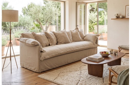 Lniana sofa 200 cm wypełniona pierzem w słonecznym pokoju dziennym z lampą stojącą