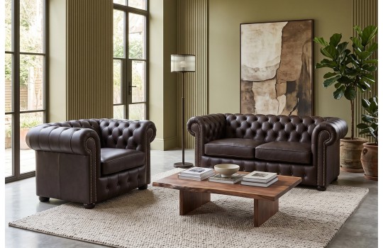 Sofa i fotel Parole w ciemnym obiciu w salonie z dużymi oknami