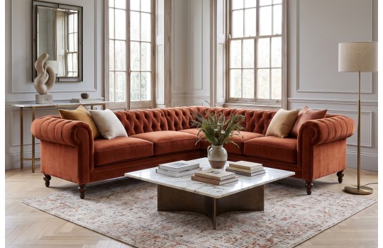 Ceglasty narożnik chesterfield Soft w jasnym salonie z dużymi oknami