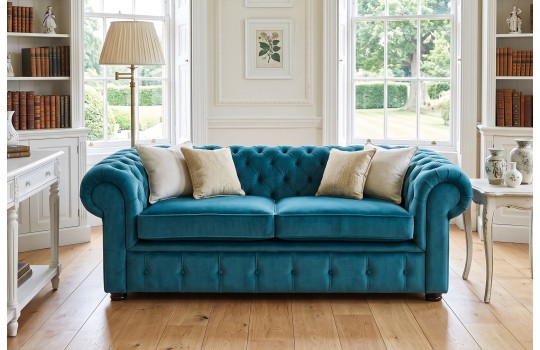 Turkusowa sofa Chesterfield Retro w salonie z biblioteczką Turkusowa sofa Chesterfield Retro w salonie z biblioteczką