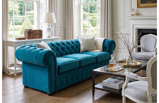 Turkusowa sofa Chesterfield Retro w salonie z kominkiem