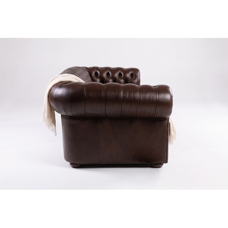 Ciemnobrązowa sofa chesterfield – ujęcie z boku, widoczny wałek i podłokietnik Ciemnobrązowa sofa chesterfield – ujęcie z boku, widoczny wałek i podłokietnik