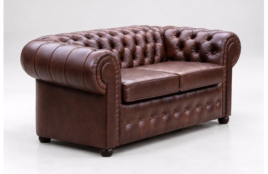 Brązowa skórzana sofa chesterfield Mati 230 cm, ujęcie z boku na zaokrąglony podłokietnik Brązowa skórzana sofa chesterfield Mati 230 cm, ujęcie z boku na zaokrąglony podłokietnik