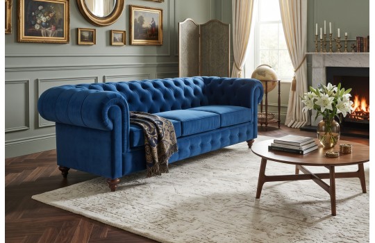 Granatowa sofa Chesterfield Globo 220 cm w salonie z kominkiem i okrągłym stolikiem Granatowa sofa Chesterfield Globo 220 cm w salonie z kominkiem i okrągłym stolikiem