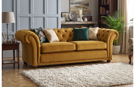Musztardowa welurowa kanapa chesterfield Sansa 233 cm w salonie z poduszkami