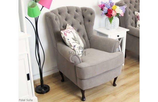 Pikowany fotel z drewnianymi nóżkami 