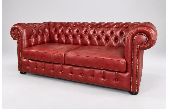 Czerwona skórzana sofa chesterfield Parole z pikowaniem i ćwiekami, ujęcie pod kątem Czerwona skórzana sofa chesterfield Parole z pikowaniem i ćwiekami, ujęcie pod kątem