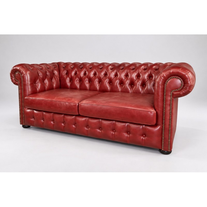 Czerwona skórzana sofa chesterfield Parole z pikowaniem i ćwiekami, ujęcie pod kątem Czerwona skórzana sofa chesterfield Parole z pikowaniem i ćwiekami, ujęcie pod kątem
