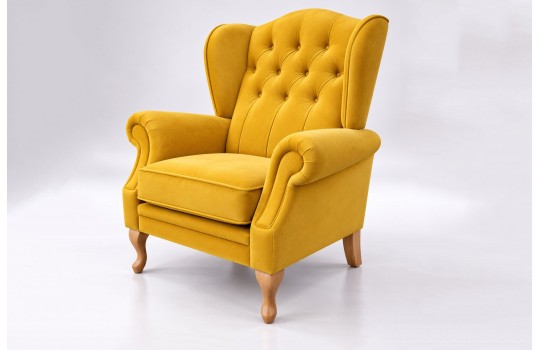 Musztardowy fotel uszak chesterfield Bertiso na jasnym tle