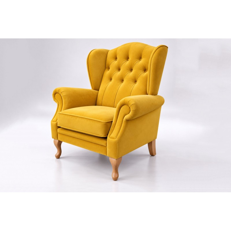 Musztardowy fotel uszak chesterfield Bertiso na jasnym tle Musztardowy fotel uszak chesterfield Bertiso na jasnym tle